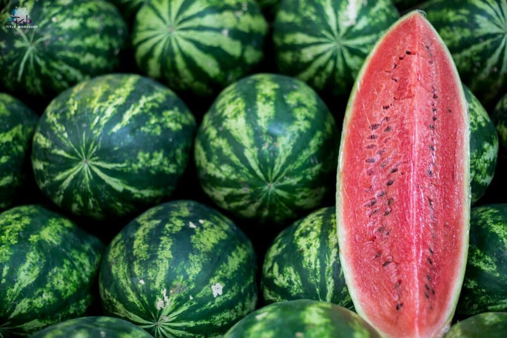 a close up of a watermelon in a pile of other watermelons